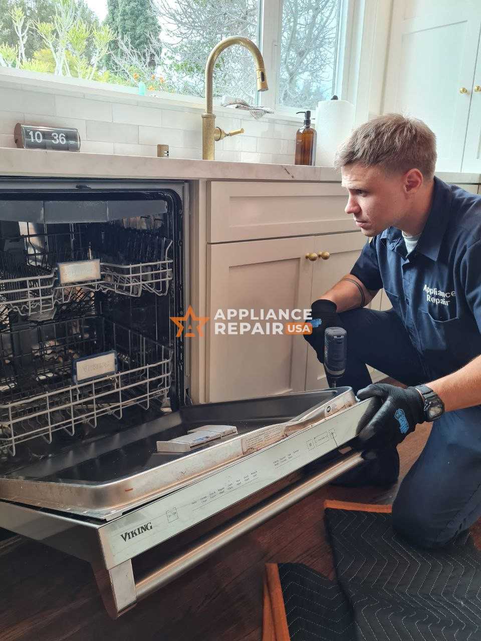 A technician in a uniform and black gloves is repairing a dishwasher