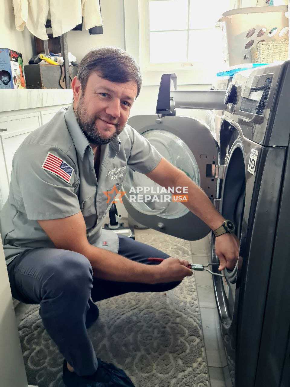 A technical expert with a tool in his hand is repairing a broken dryer
