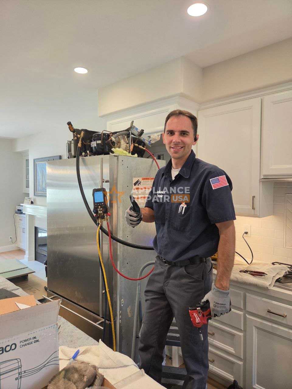 A technician in a uniform and black gloves is repairing a dishwasher