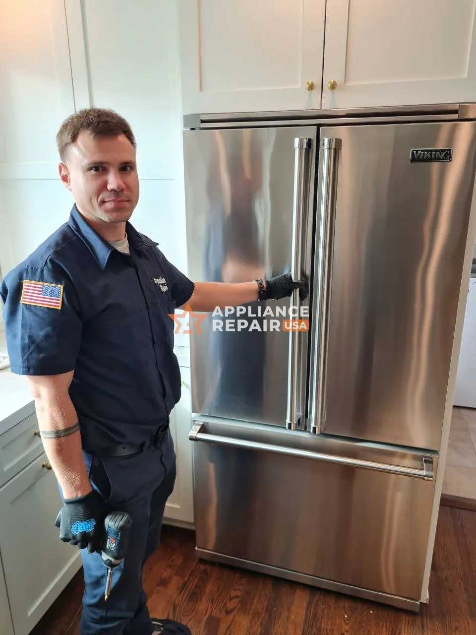 Technician in uniform preparing to repair a refrigerator