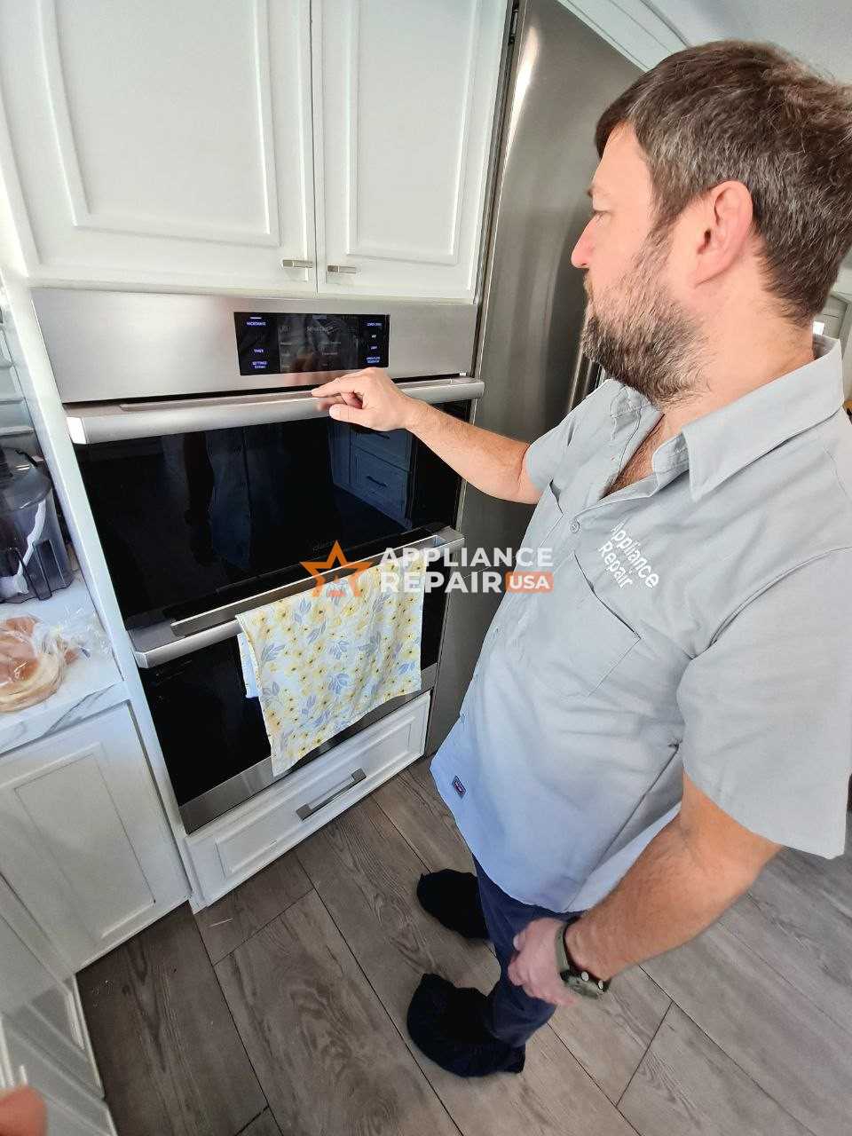 A man inspects an oven in a kitchen