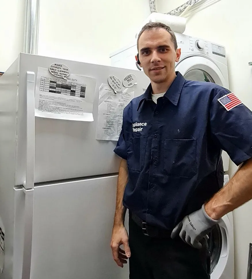 Business owner-operator in uniform standing in front of refrigerator